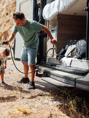 father-and-children-cooling-down-by-camper-van and rv plumbing